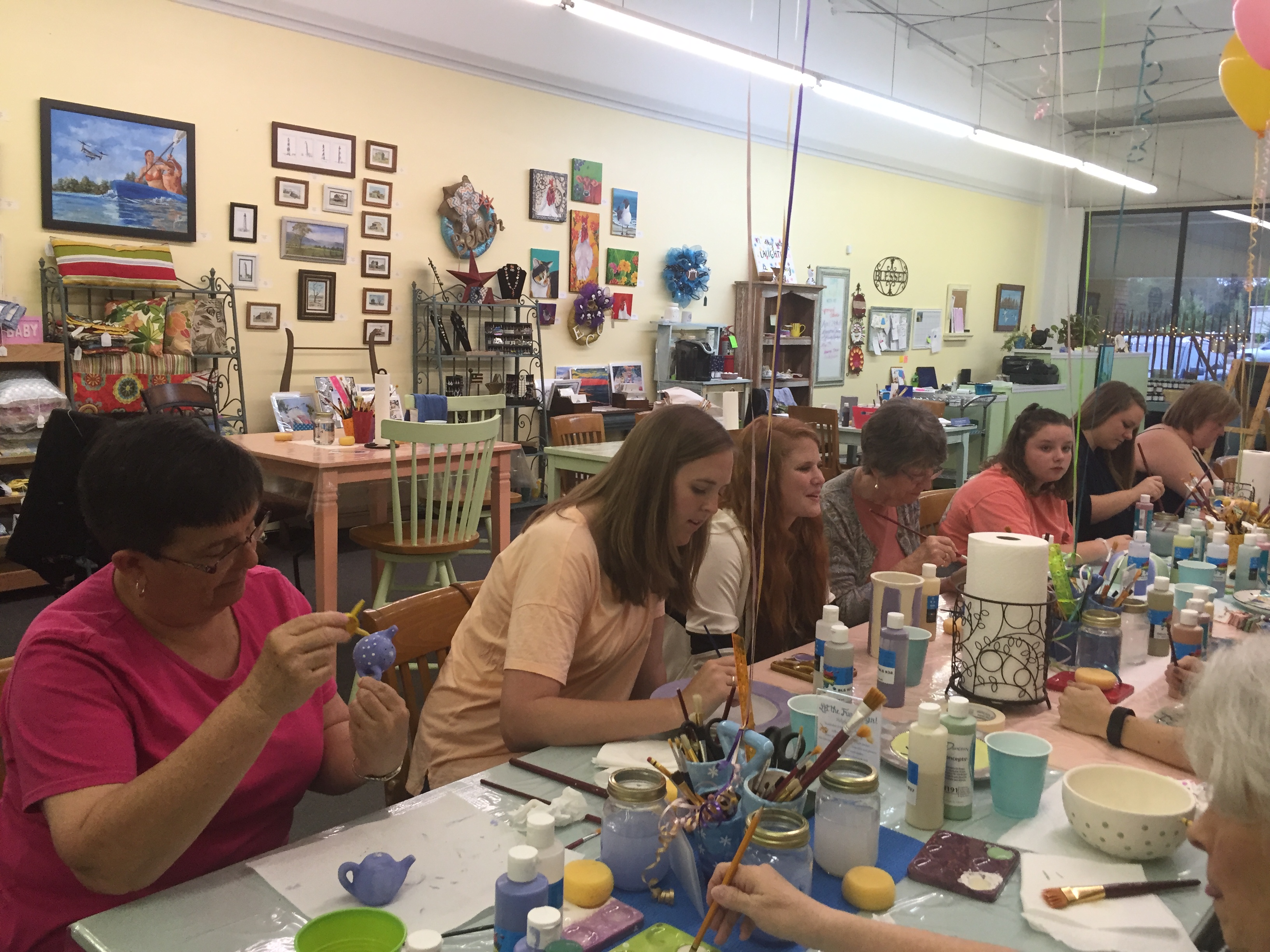 Wedding shower guests painting pottery